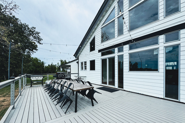 Main deck with dining seating, twinkle lights, a Blackstone grill, and a gas grill.