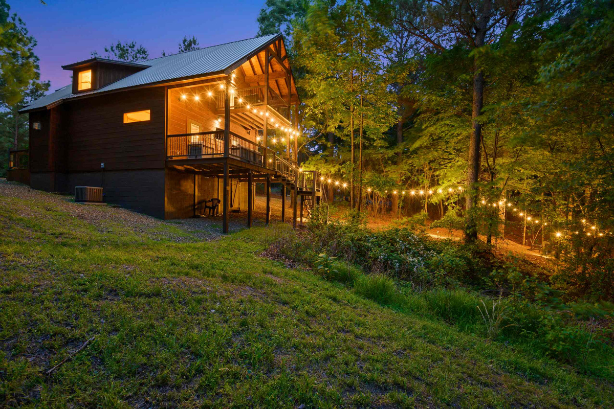 Exterior: Twinkling lights drape the deck, inviting you to unwind in nature's embrace!