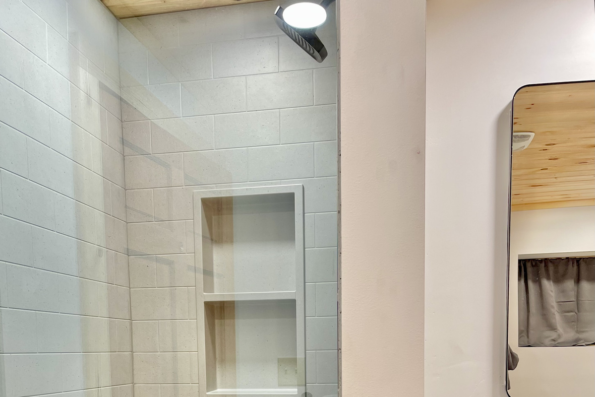 Ensuite bathroom 3 has a modern step-in shower with a rainfall shower head and glass door. 
