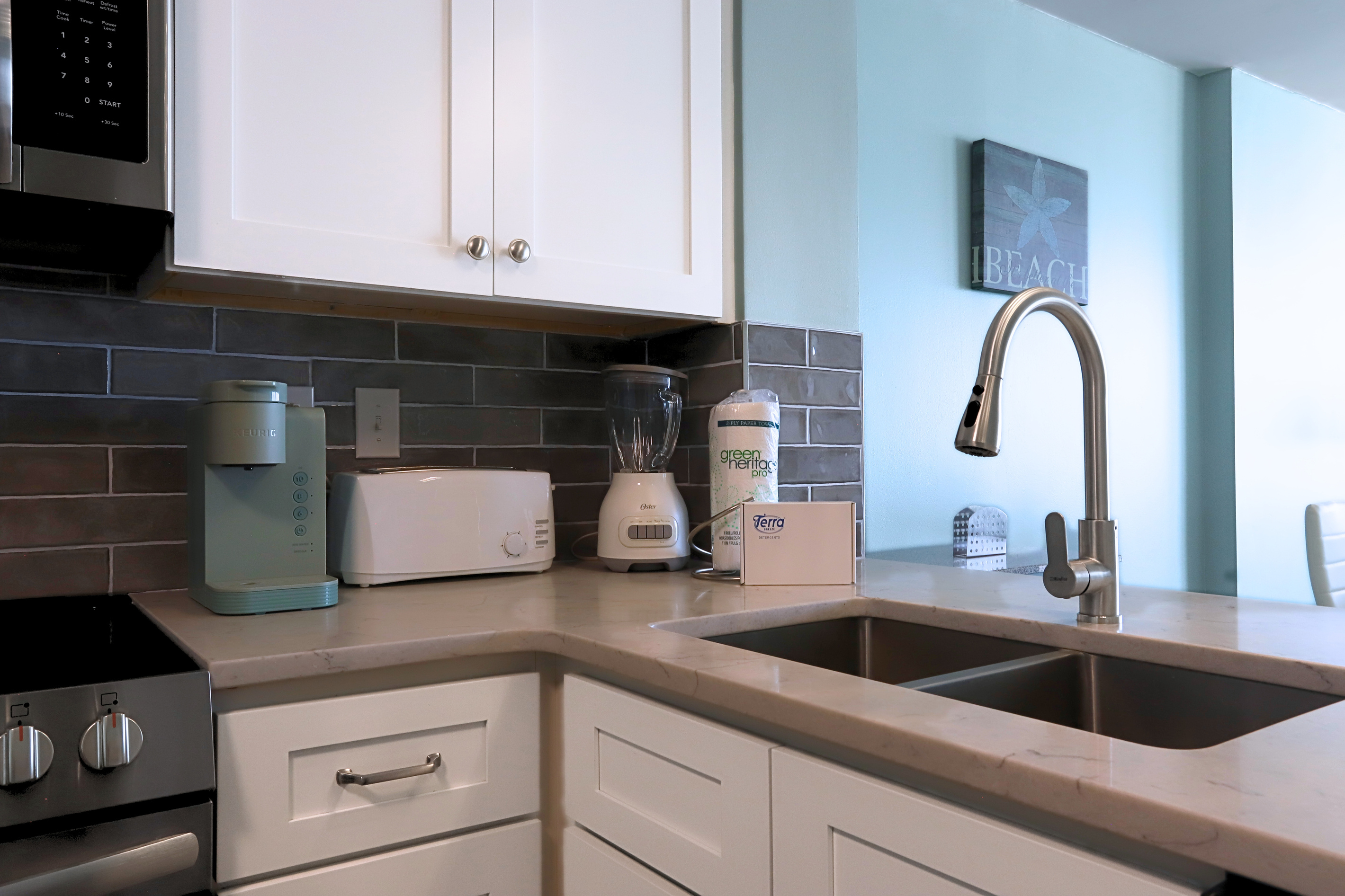 A modern kitchen featuring a sleek sink, coffee maker, blender, and an assortment of knives in various sizes—designed for convenience and efficiency in meal preparation.