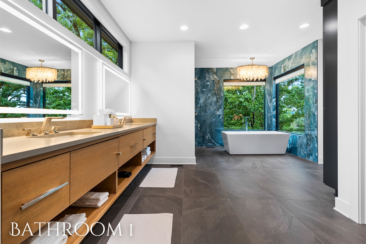 Step into this luxurious bathroom featuring a double vanity and a stunning view from the bathtub, perfect for relaxation.