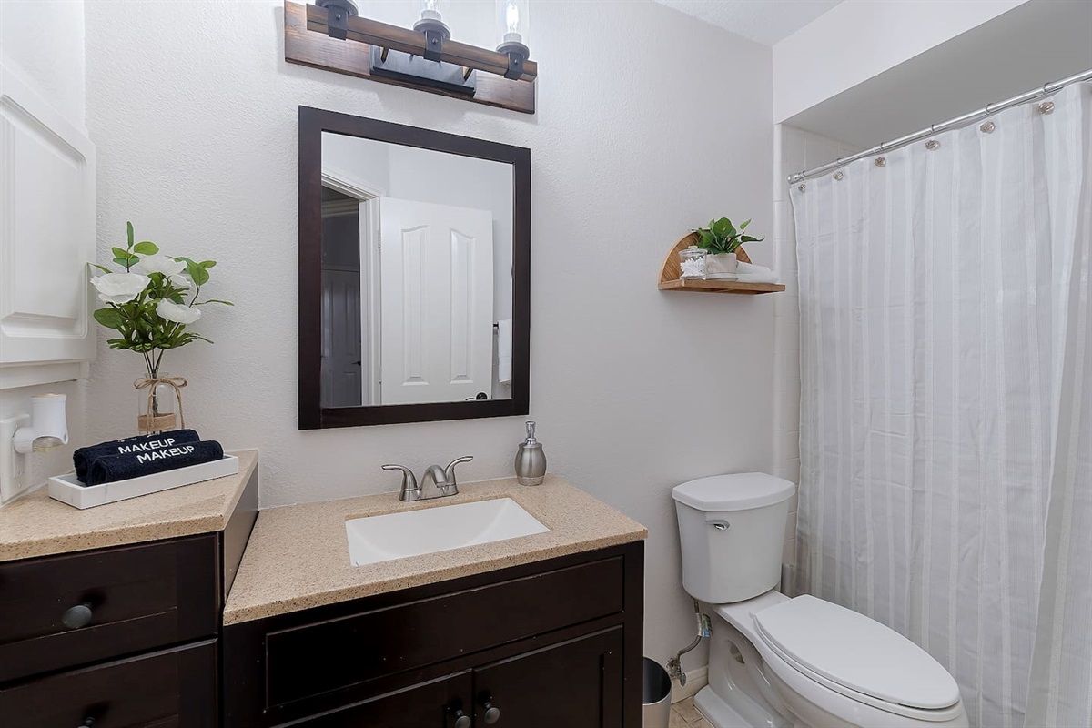 Step into this luxurious bathroom featuring a sleek sink and mirror combo and a spacious walk-in shower. Pamper yourself in style and comfort.