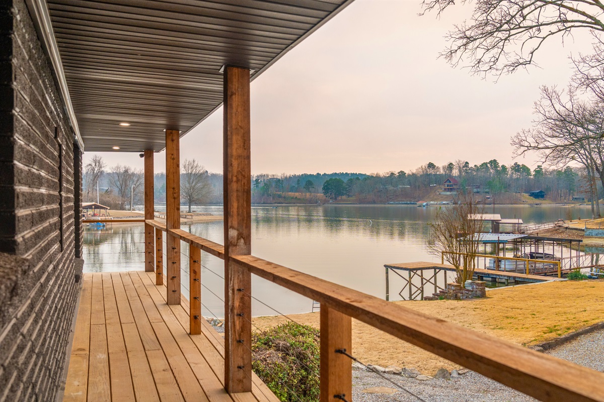 Stretching along the home, the covered porch offers a shaded place to sip coffee, relax, and watch the lake throughout the day.
