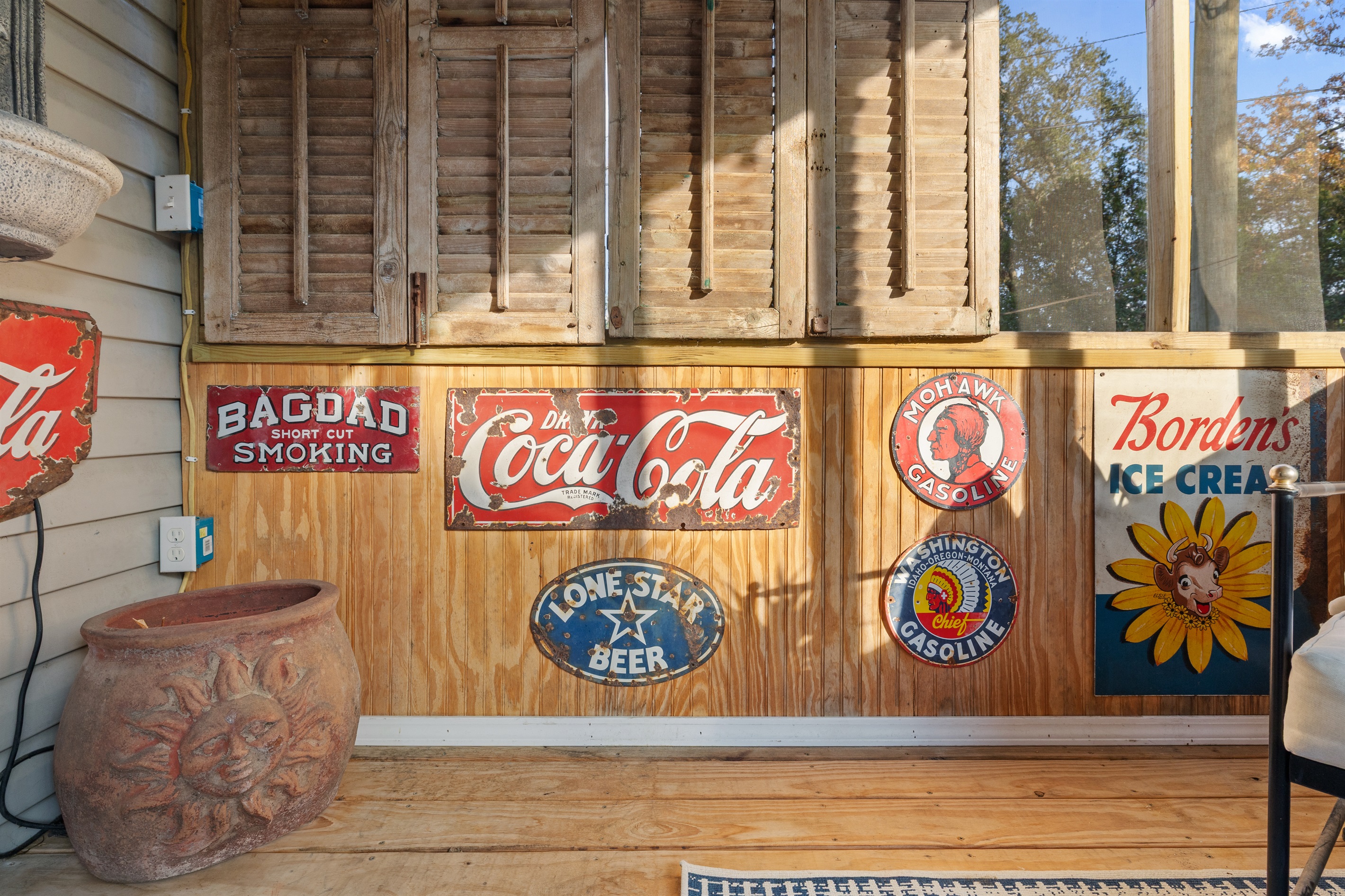 Let the morning sun and centuries-old oaks wrap you in Laurel comfort—this vintage screened porch is made for slowing down.