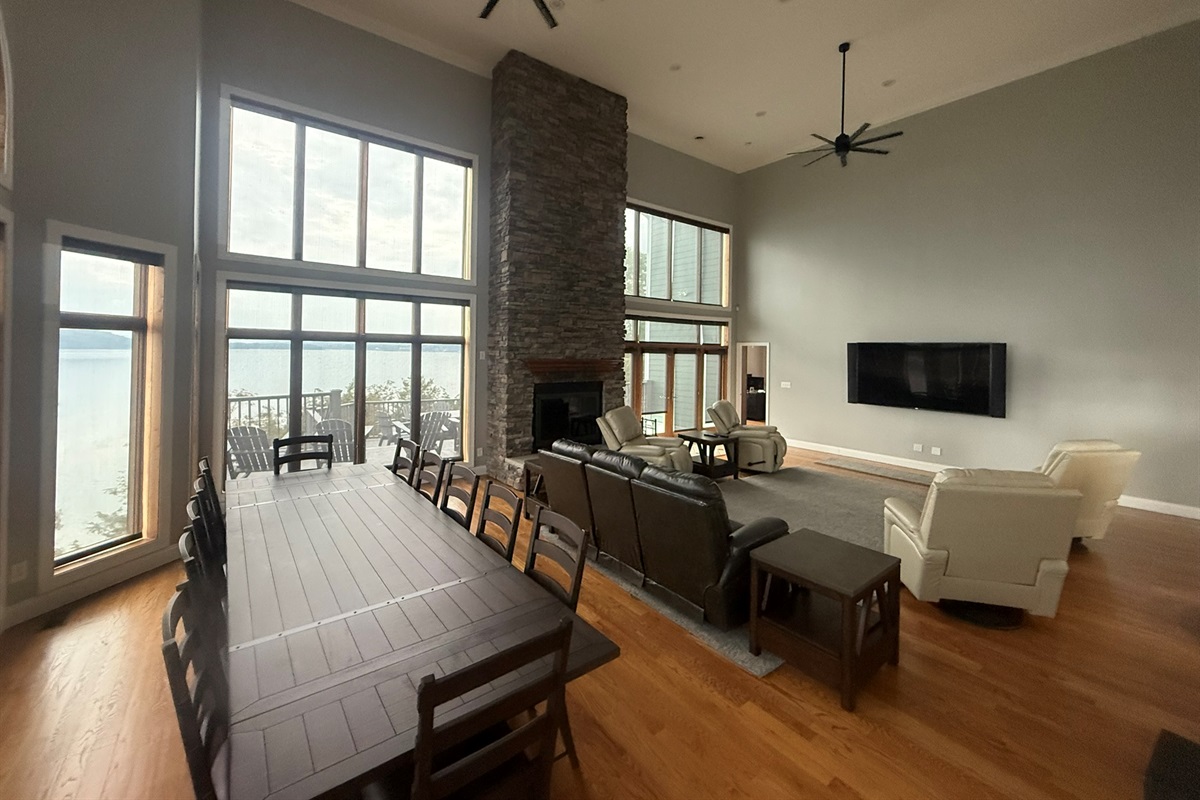 A large dining table comfortably seats 12 people, featuring very cozy, cushioned seats.  Equipped with 75 x 43 inch Theatre room-style top quality TV
