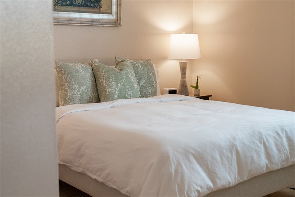 Close-up of bed pillows and bedside lighting