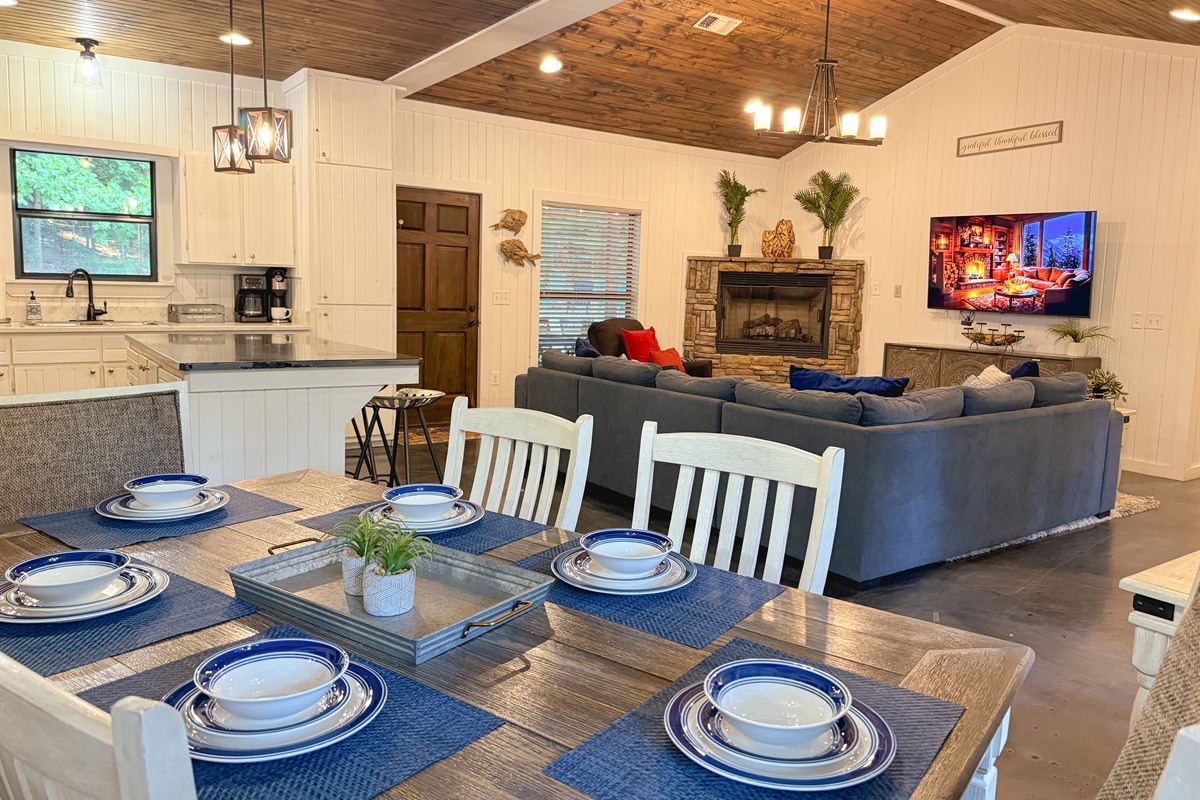 Spacious open floor plan with cozy seating, rustic fireplace, and fully stocked kitchen&mdash;perfect for gathering the whole crew.