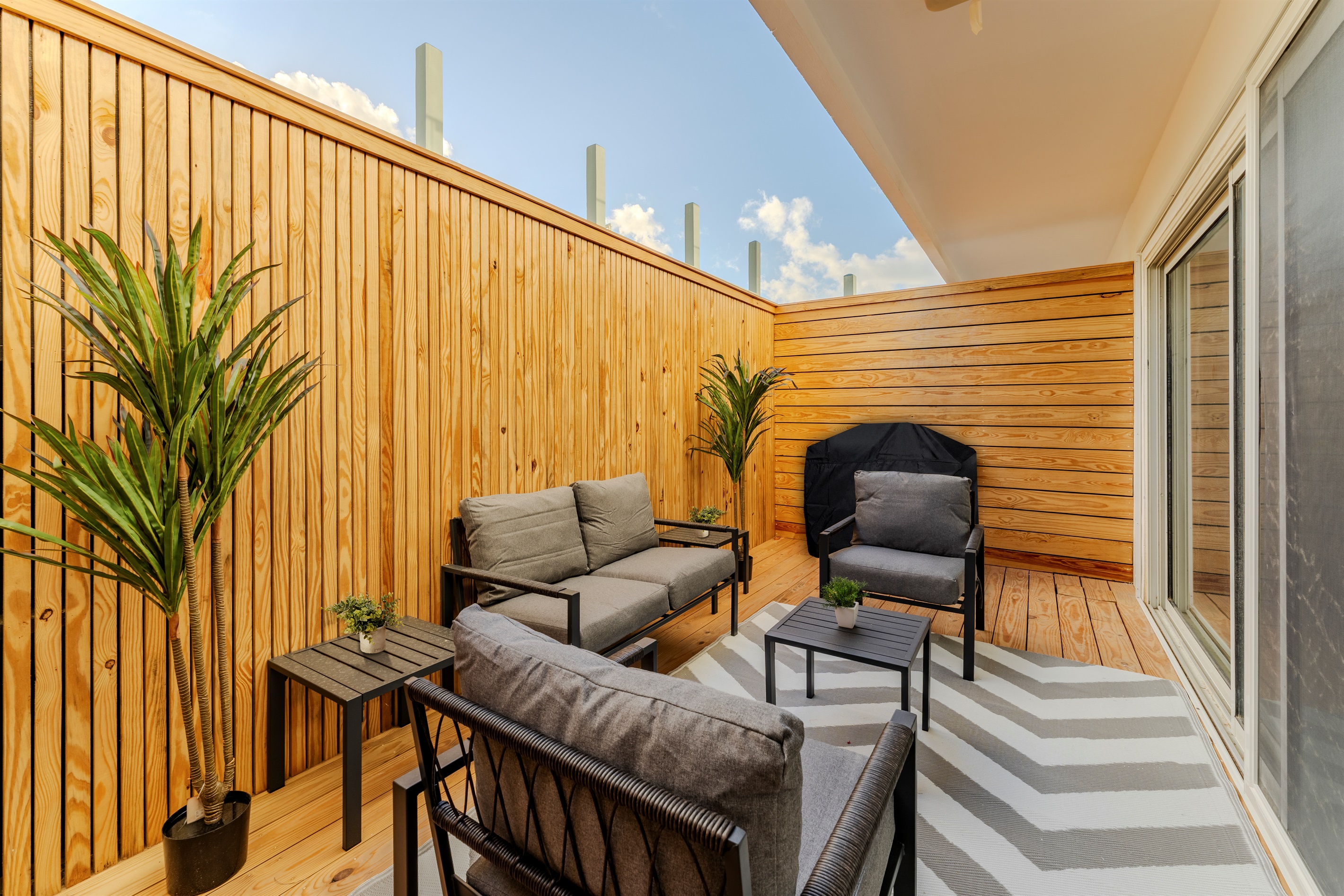 Sun‑Drenched Private Terrace with Comfy Lounge Seating & Warm Wood Accents