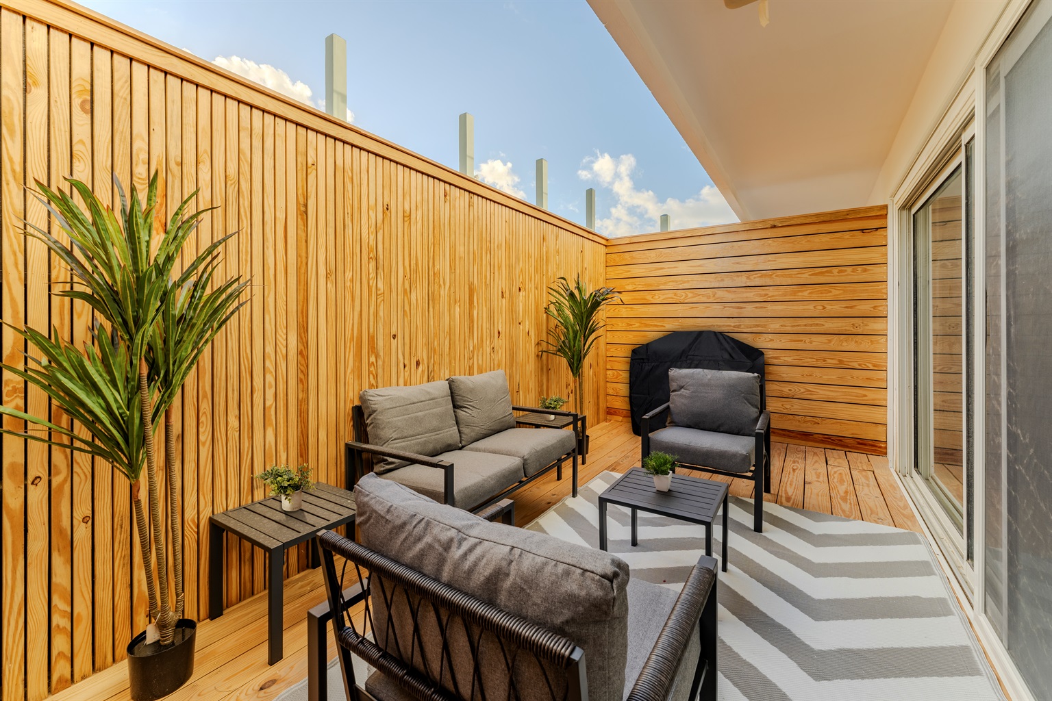Sun‑Drenched Private Terrace with Comfy Lounge Seating & Warm Wood Accents