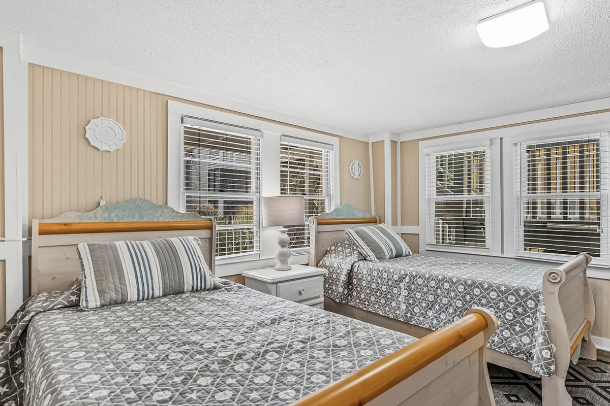 A bright, airy bedroom downstairs with soft, neutral bedding for easy rest. ⭐