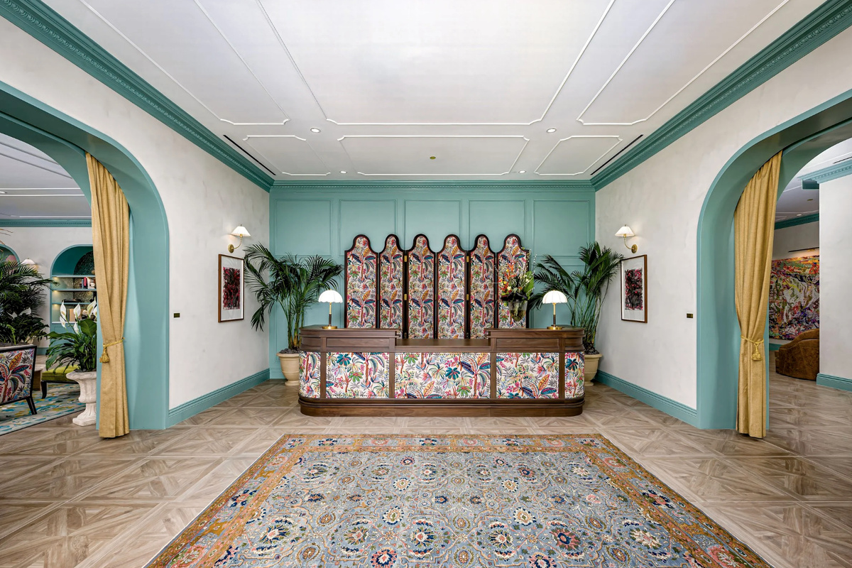 The concierge and reception salon - arched windows, soft teal tones and a warm, hotel-style welcome.