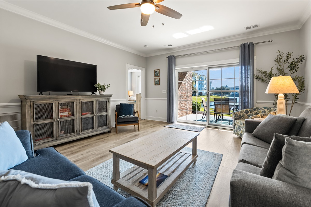 A cozy TV lounge with a clear view of the sunroom, offering natural light and a relaxing atmosphere—perfect for enjoying entertainment or unwinding in a bright, inviting space.