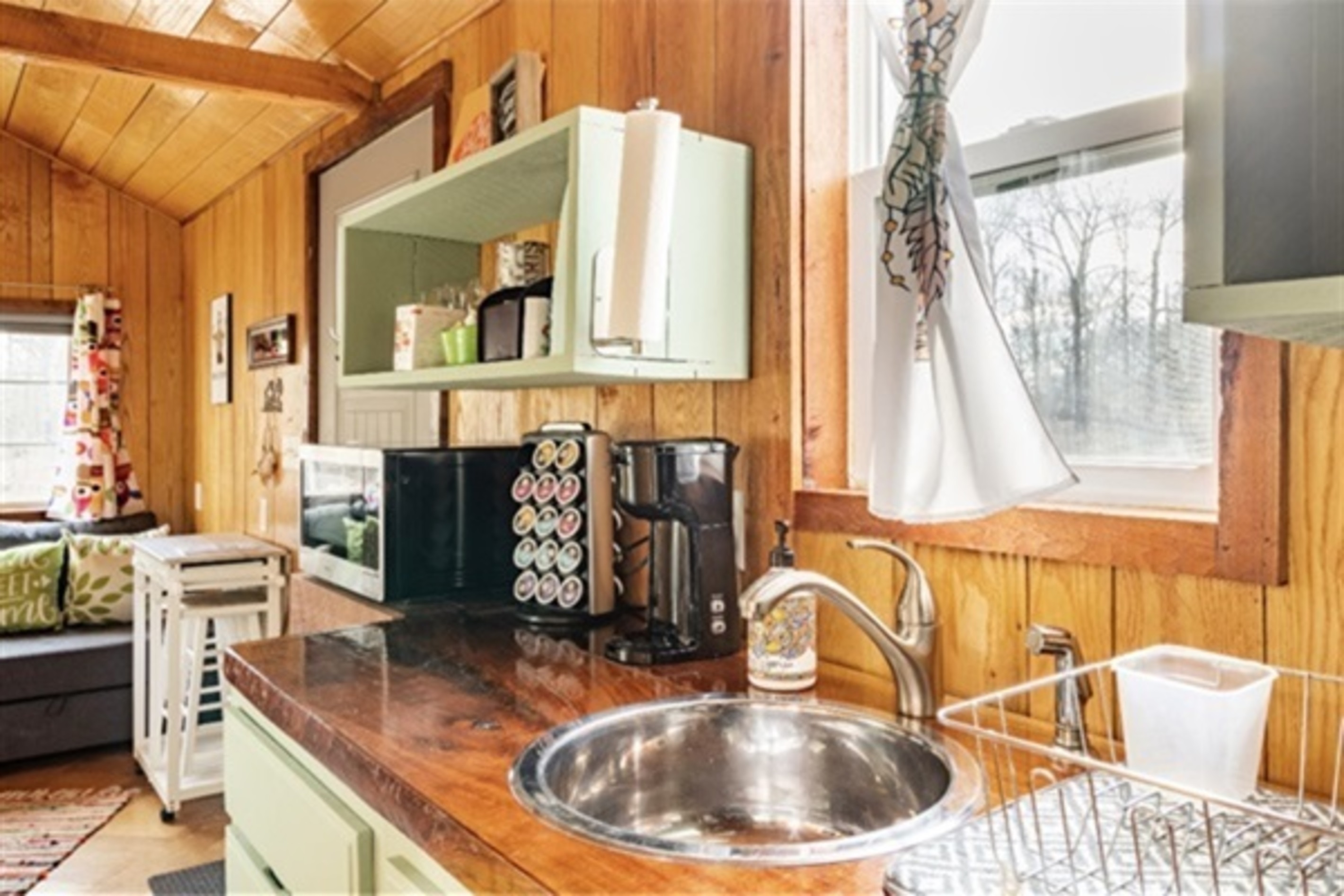 Embrace the charm of a well-equipped kitchenette that includes a double electric hot plate, toaster, microwave, air fryer, electric skillet, spice rack and coffee bar.