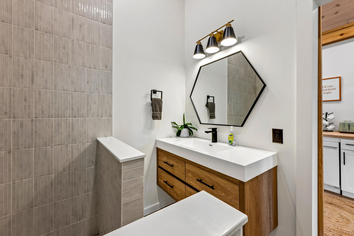 Rainfall shower with hand-held ceiling skylight and provided shampoo/conditioner/body wash.