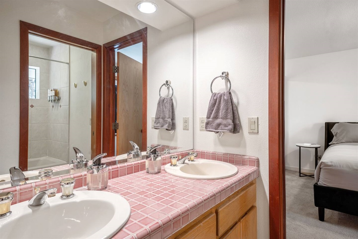 Ensuite jack-and-jill bathroom has an outer room with two sinks and an inner room with toilet and combination tub/shower.