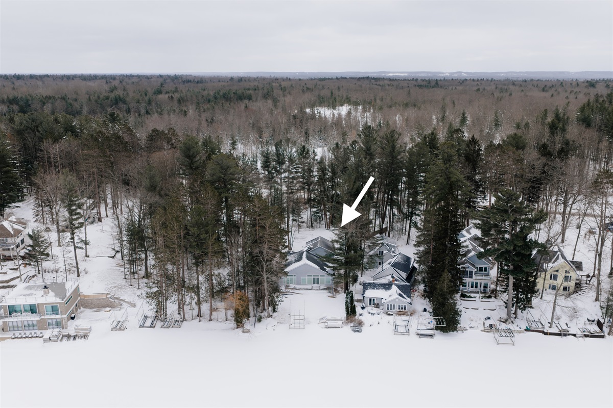 Lakeside view of wooded lot to the East (left) with a privacy fence along the West (right) property line.