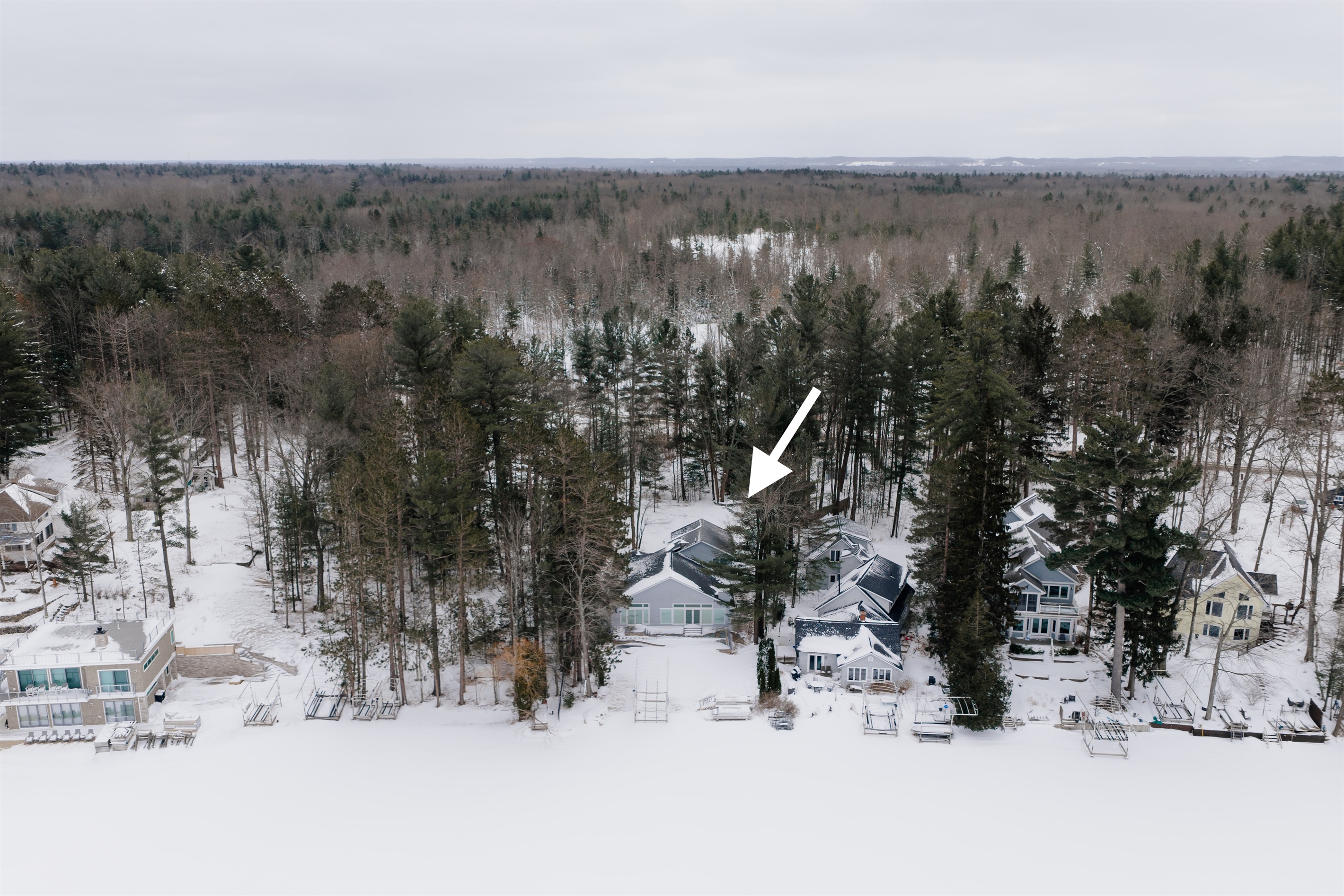 Lakeside view of wooded lot to the East (left) with a privacy fence along the West (right) property line.