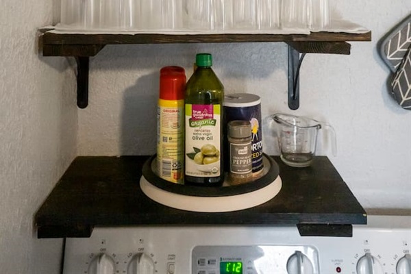 Open shelving stocked with glasses and cooking supplies, offering easy access to everything you need for dining and meal preparation.