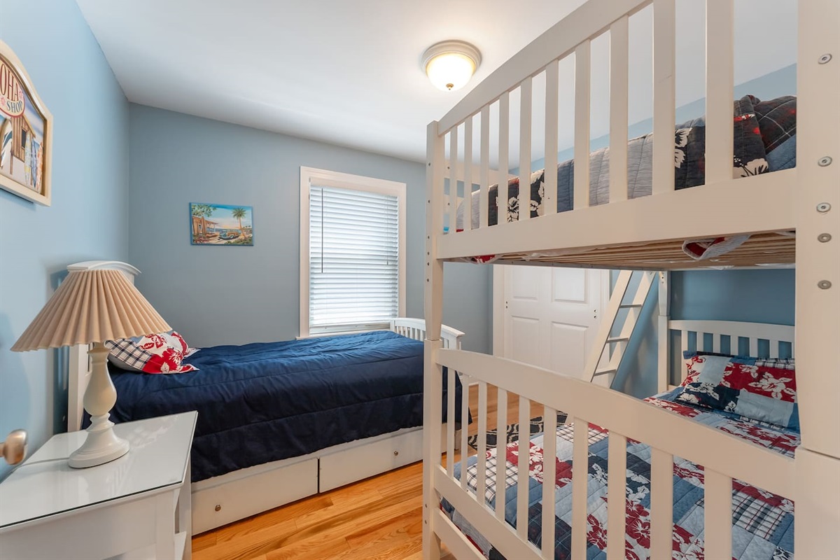 Bedroom features bunk beds and a single bed with a large closet for storage. 