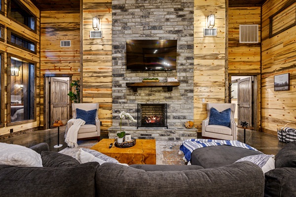 Elegant cabin living space with fireplace, soaring ceilings, and charm