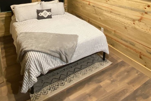 Upstairs: queen bed, smart TV, box fan, privacy shades, and child safety gate