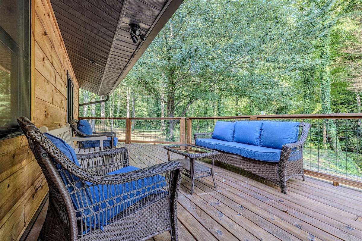A peaceful overlook deck with conversational seating invites you to sip coffee above the babbling creek, surrounded by the layered beauty of the Smoky Mountain forest.
