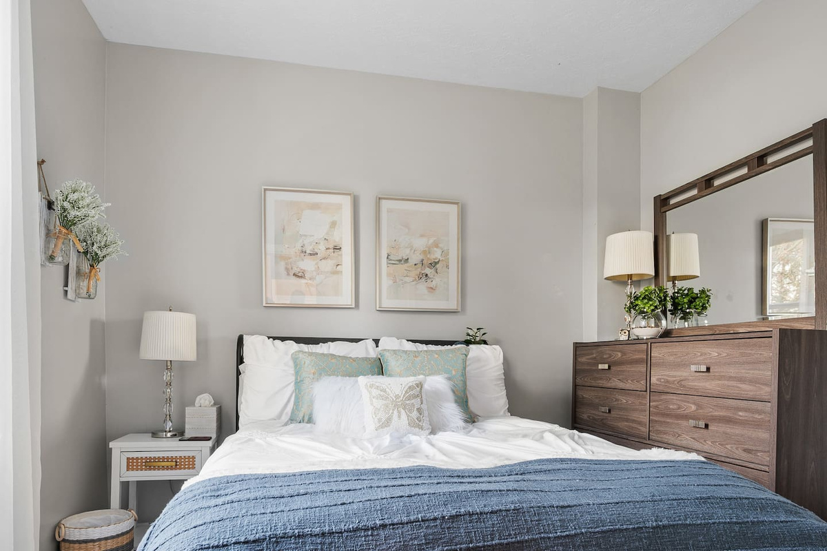Main-floor bedroom with a double bed, soft bedding, and warm natural light.