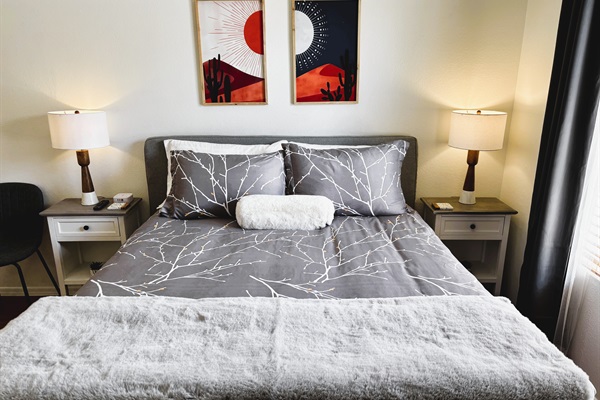 Bedroom with queen bed, smart TV, ceiling fan, blackout curtains and linens