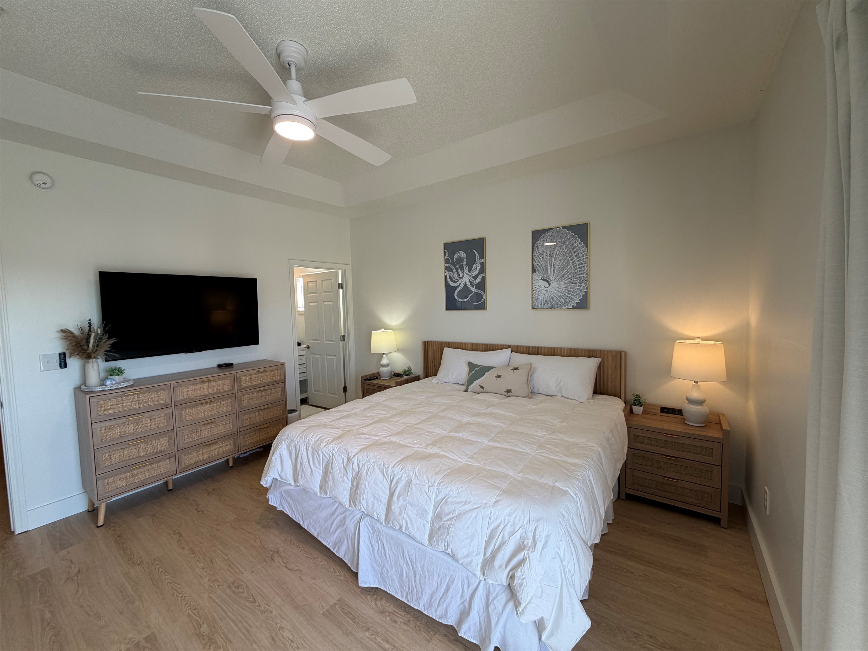 Newly renovated master bedroom!  There is a 55 inch TV in both bedrooms. The TV swings out from the wall, so you can angle it towards the bed for a better view or hook up your computer or Play Station! 