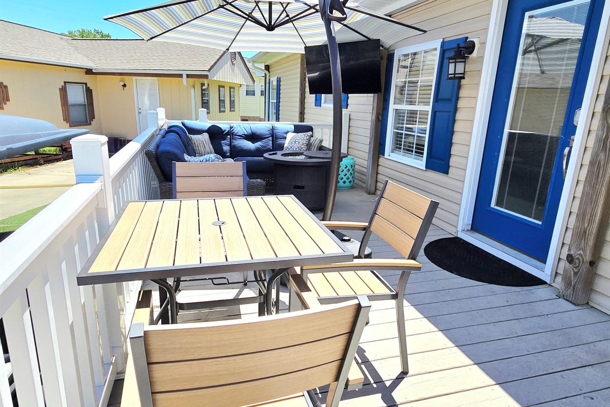 Lounge area on the balcony w/ TV and table for 3