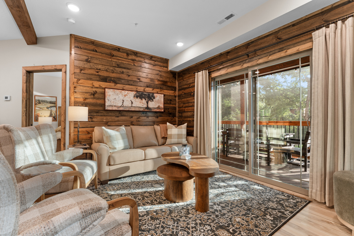 The living room is cozy and soaked with setting sunlight. Just a step through the slider to enjoy your screened in deck.