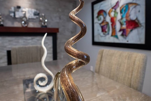 beautiful dining room with a glass sculpture on the table and a painting on the wall.