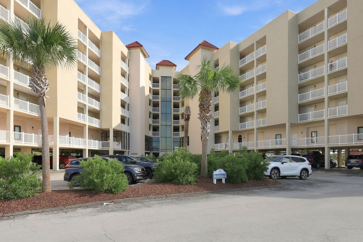 Resort grounds and courtyard area featuring palm trees and easy access to covered parking.