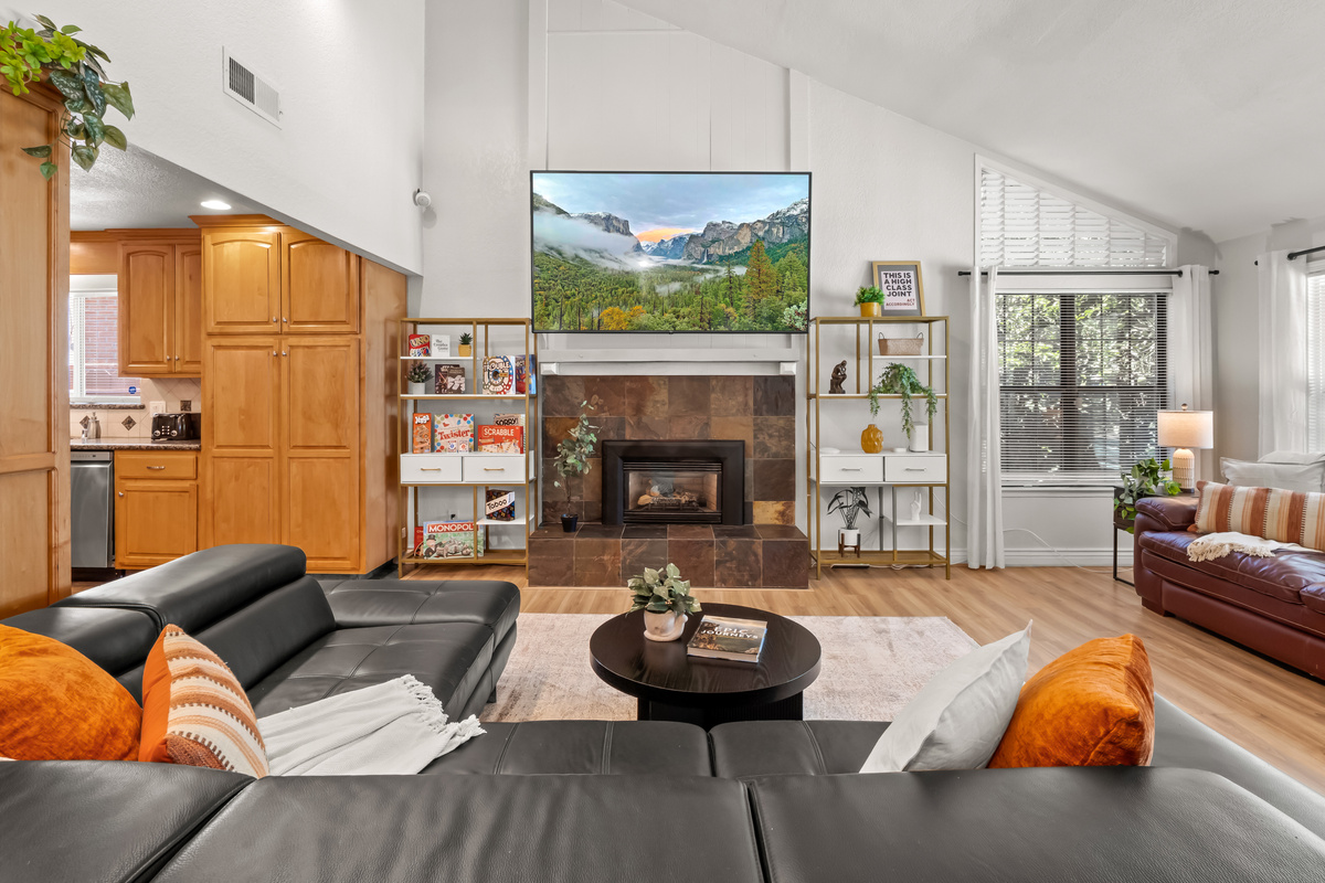 Gather everyone together in this bright and welcoming living room, where comfortable seating, a cozy fireplace, and a large TV create the perfect setting for relaxing after a full day.