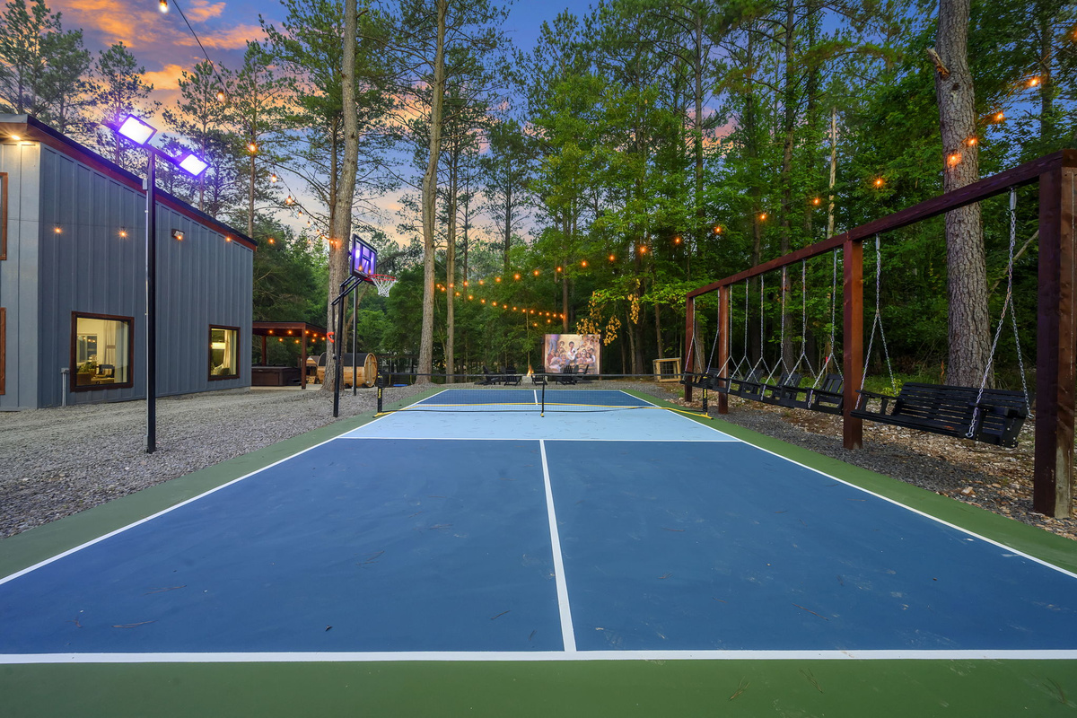 Your own pickleball + basketball court under the pines, with swings for the cheering section. When the games end, gather by the fire pit for an outdoor movie under the stars.
