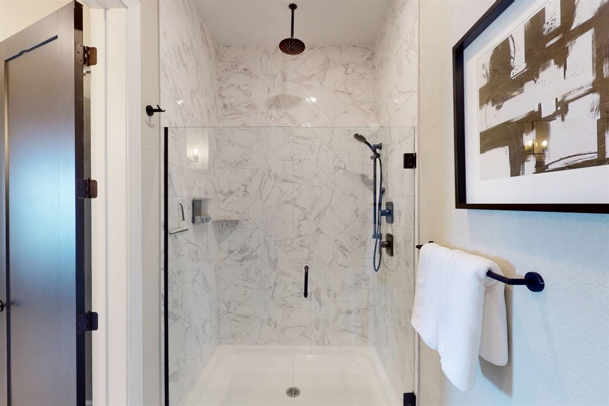Private Master Bathroom en suite includes modern fixtures, granite counter tops, double sinks, large closet, and seperate oversized shower with rainwater ceiling shower head, floor to ceiling quartz tiles, and shower wand, plus toilet.