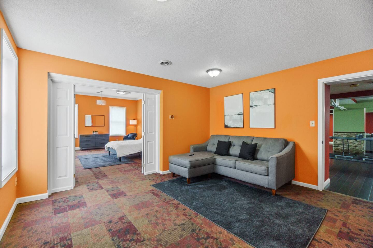 Spacious and wide bedroom featuring a king-sized bed and a cozy couch, offering plenty of room to relax and unwind.