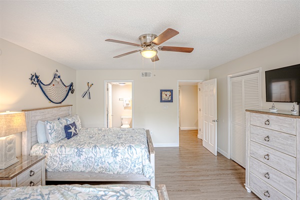 Guest bedroom with two queen beds, ceiling fan, and smart TV