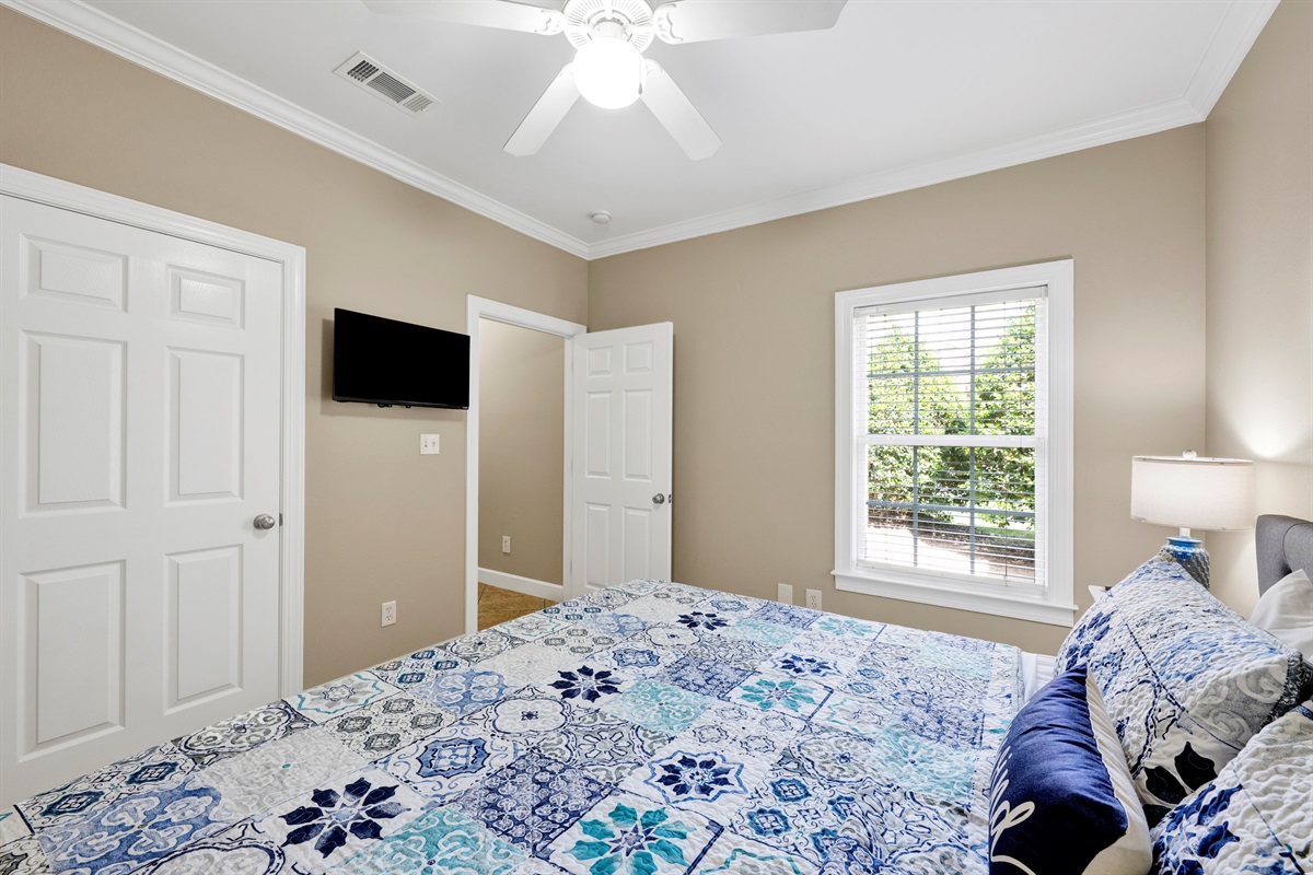 Bedroom 2 offers a king bed, ceiling fan and wall mounted smart tv 