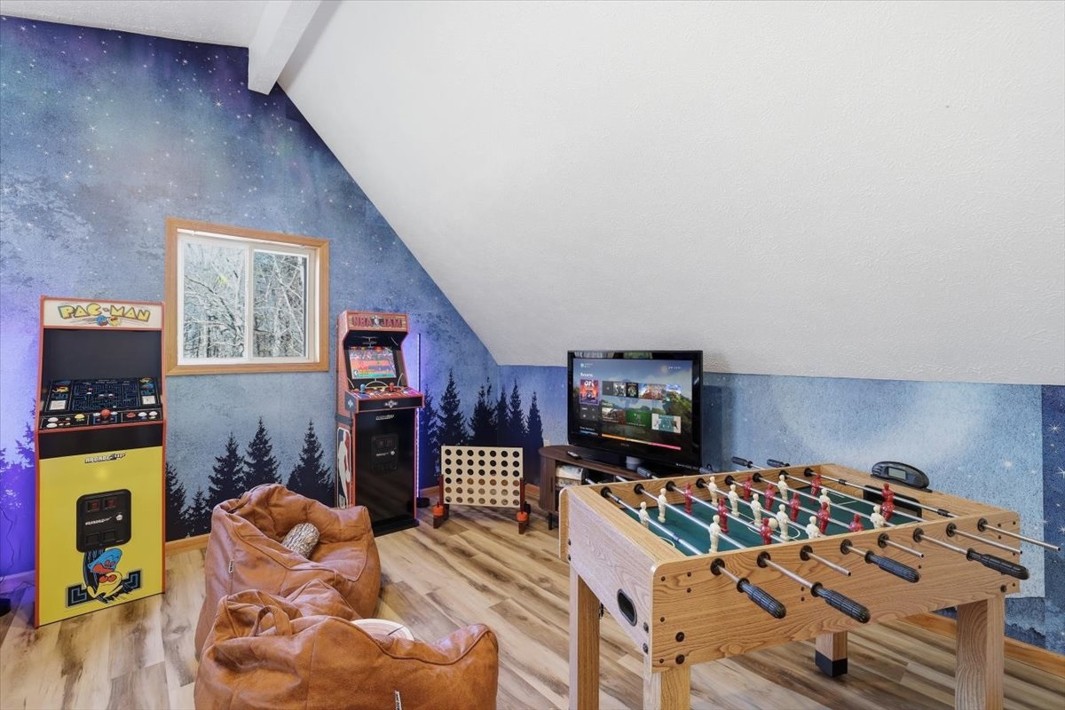 The upstairs bedroom where the fun never stops! Bunk beds, arcade games and foosball all waiting for your crew