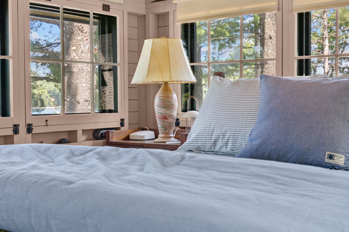 Settle into the king-size bed, turn on the bedside lamp, and unwind surrounded by charming windows and the cozy cottage feel of your lake getaway.