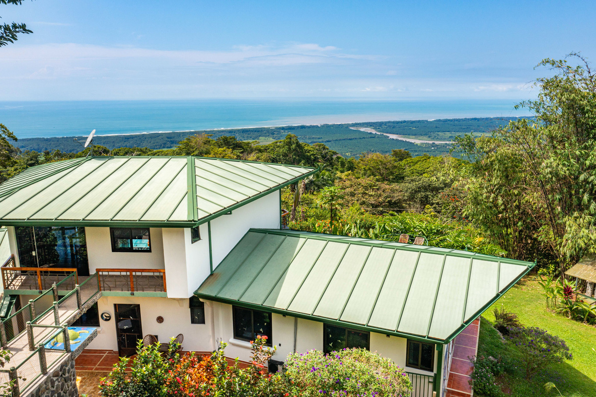 Aerial exterior of Casa Infinity with Pacific Ocean backdrop and lush grounds