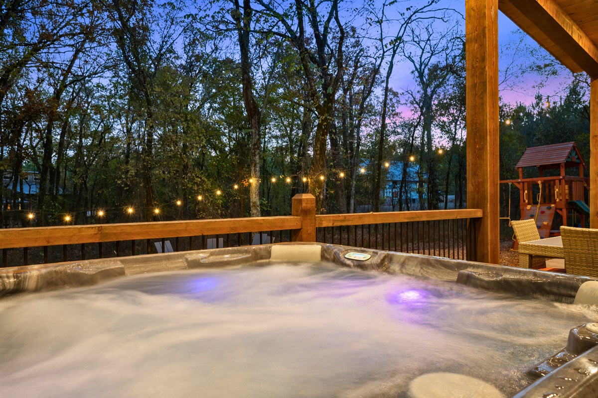 Let the soothing sounds of bubbling water and twinkling string lights melt your worries away in this inviting forest-view hot tub.