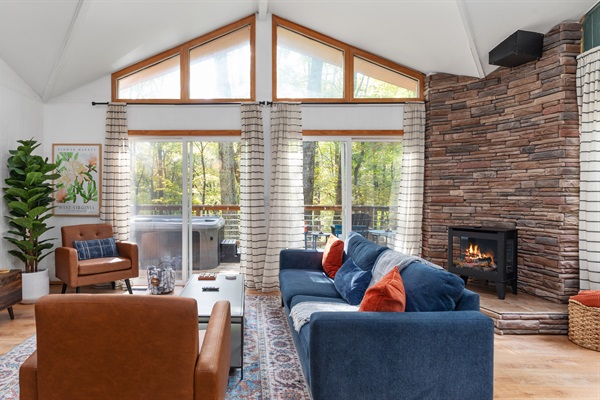 Spacious living room with cozy couch, Roku TV, and electric fireplace—high ceilings and easy deck access make it the perfect place to unwind.