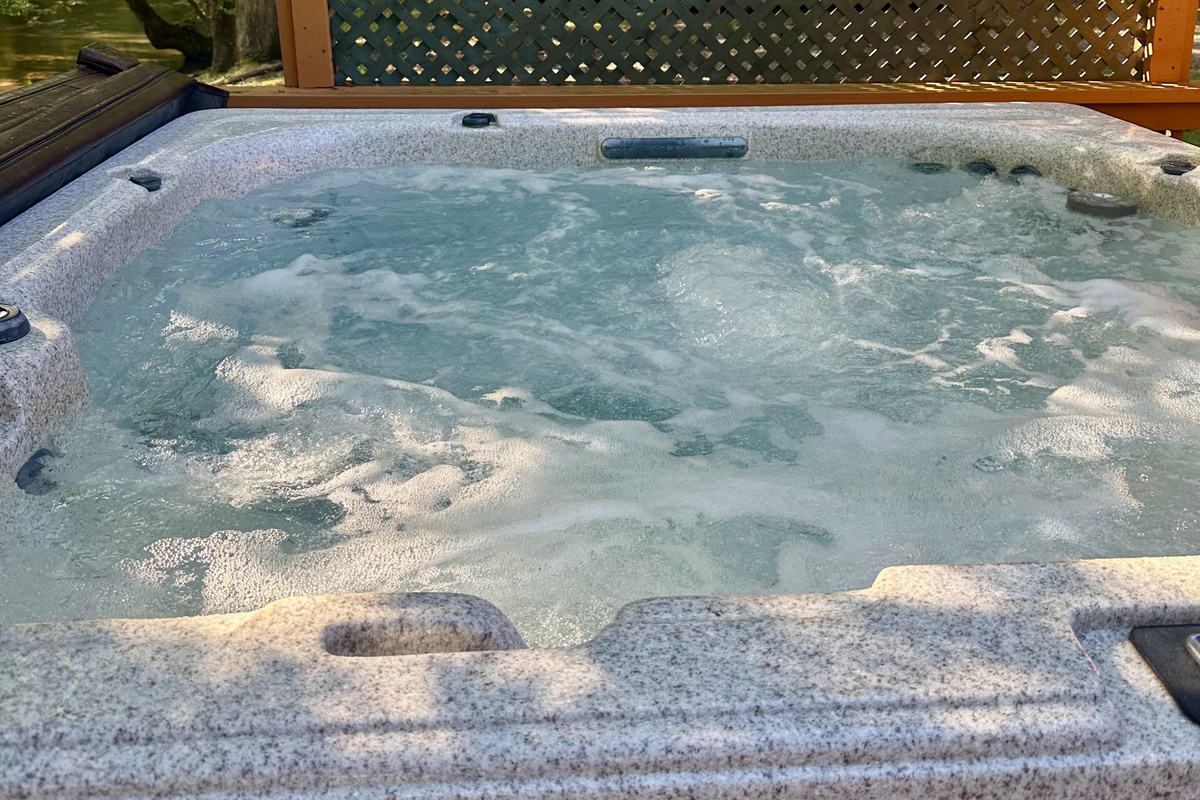 Relax in the private outdoor hot tub at Creekside Paradise while enjoying views of Cosby Creek and the peaceful Smoky Mountain surroundings.
