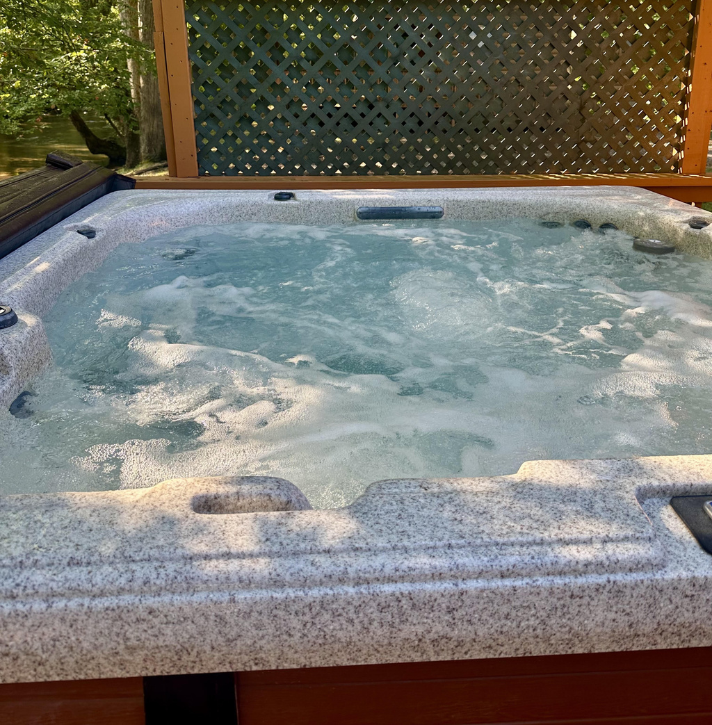 Relax in the private outdoor hot tub at Creekside Paradise while enjoying views of Cosby Creek and the peaceful Smoky Mountain surroundings.