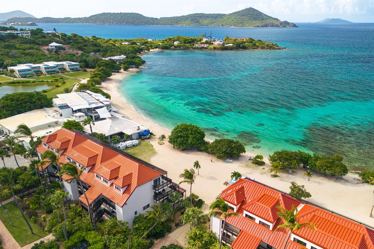 second building from all the action of Sapphire beach, with parasailing and beach chairs