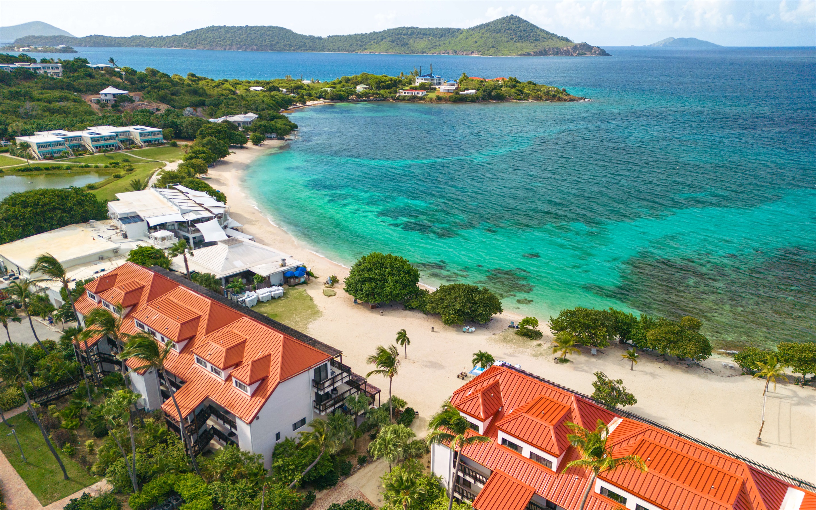 second building from all the action of Sapphire beach, with parasailing and beach chairs
