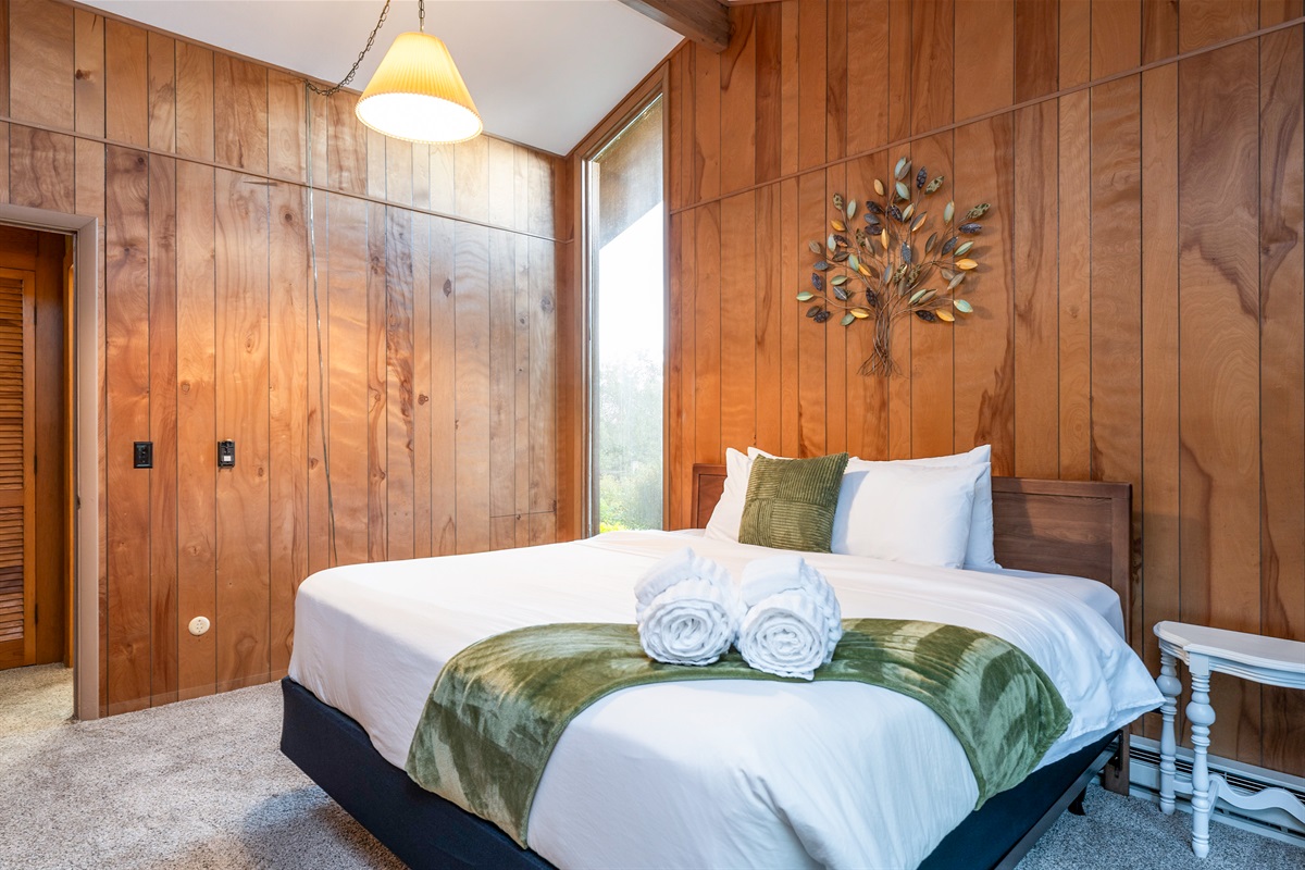 Inviting bedroom with cozy wood accents and fresh linens, designed for restful nights.