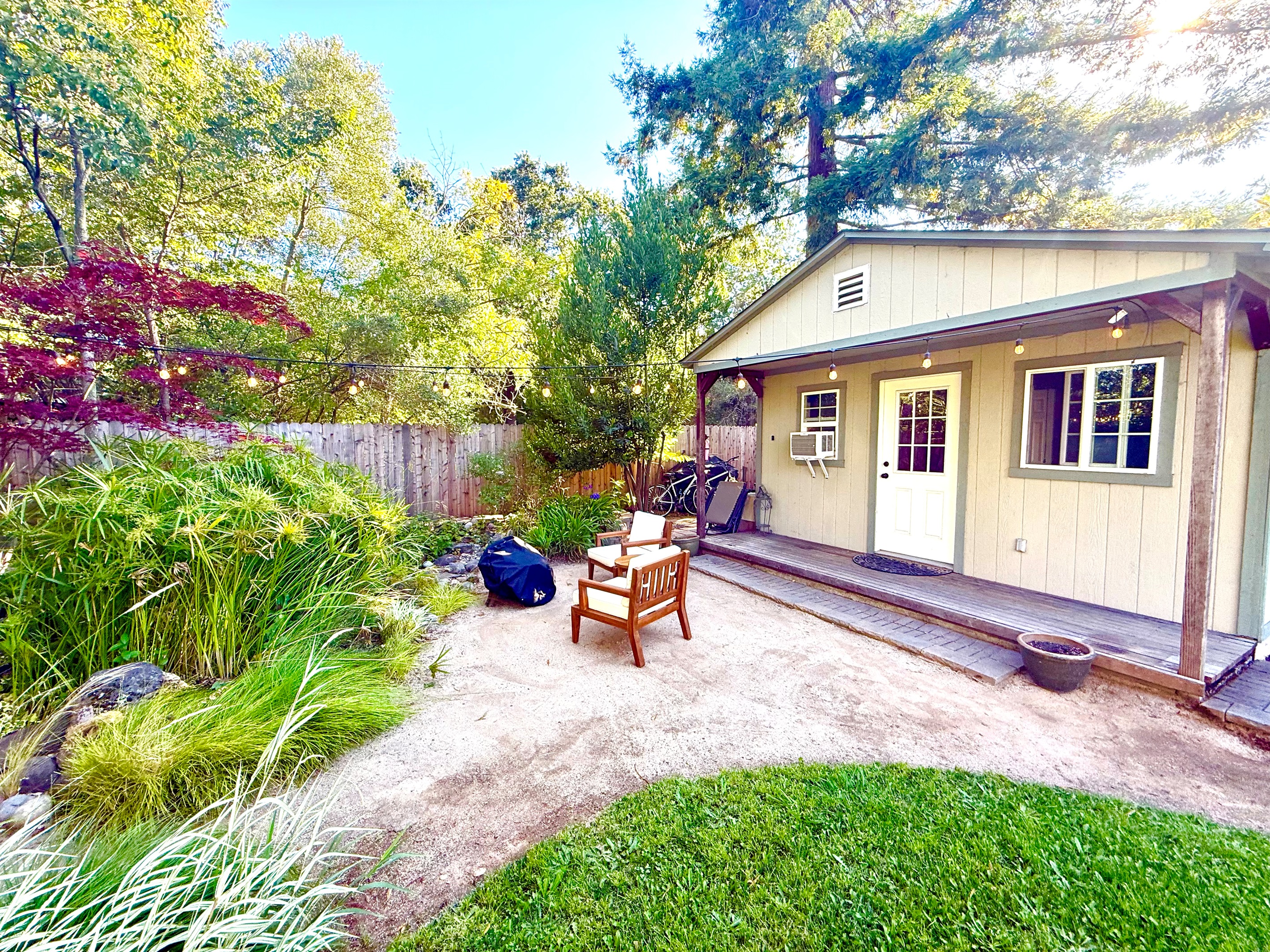 Front view of the home nestled among trees & greenery